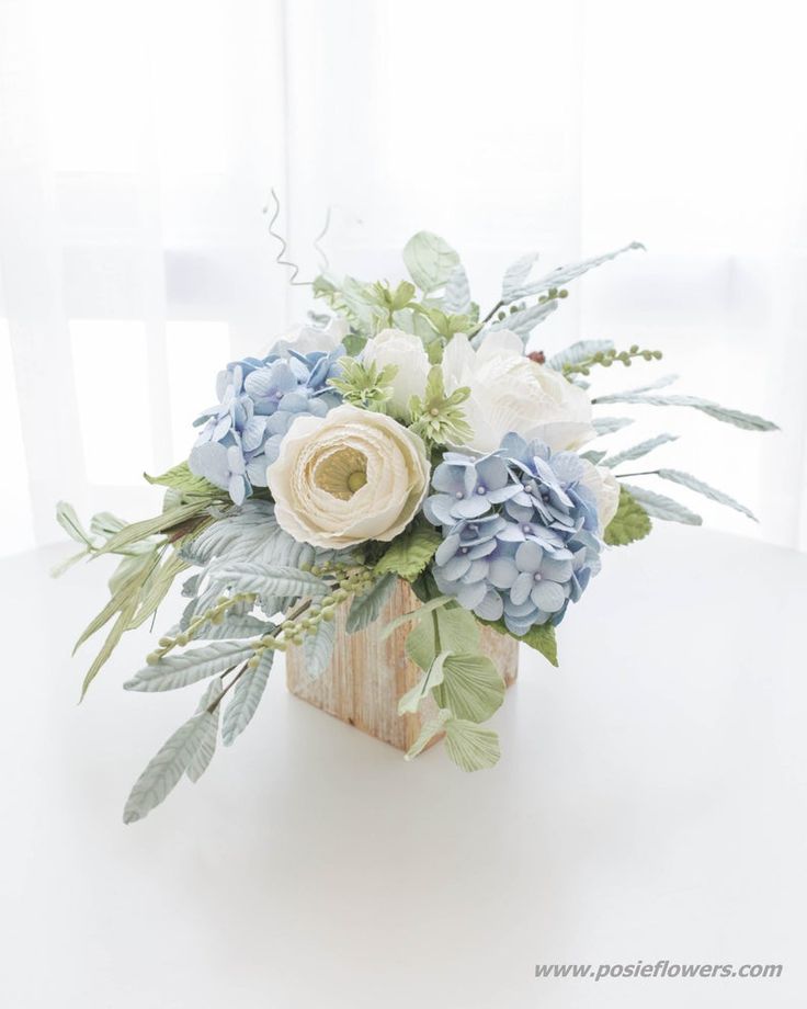 a bouquet of blue and white flowers on a table