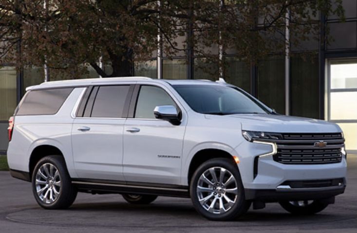 a white chevrolet suburban parked in front of a building