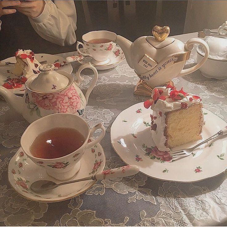 there is a piece of cake on the table with tea cups and saucers next to it