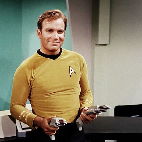 a man in a star trek uniform holding two remotes