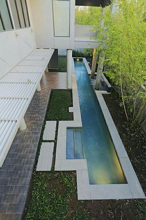 a modern house with a small pool in the middle of it's lawn area