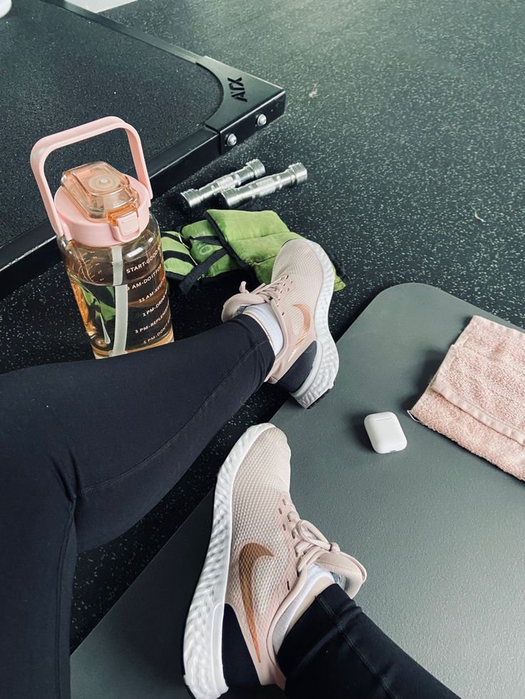 a person is sitting on a table with their feet propped up next to a water bottle