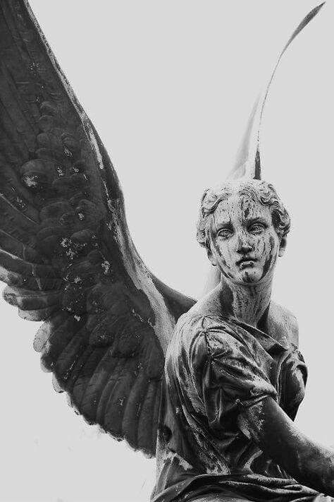 a statue with wings on top of it's head and hands in the air