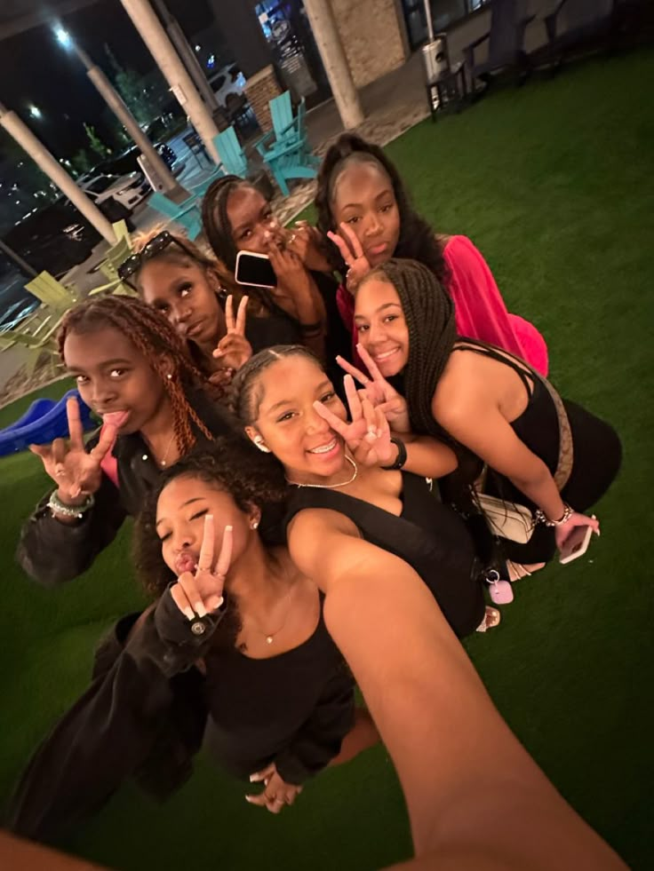 a group of young women posing for a photo in front of a building at night