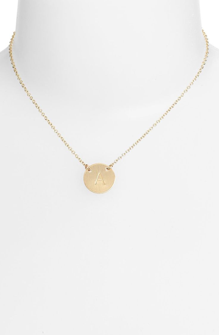 From humble beginnings to a fully staffed warehouse in Bend, Oregon, Nashelle remains true to its original purpose—handmade jewelry crafted with love and intention. The initial necklace is no different, with a hand-stamped pendant anchored by two rings for a shorter fit, making it the perfect layering piece. 15" length; 1" extender. 1/2" pendant drop. Spring-ring closure. 14k-gold fill. By Nashelle; made in the USA. Yellow Gold Round Necklace With Hallmark, Formal Gold Round Disc Jewelry, Gold Initial Pendant Jewelry With Hallmark, Adjustable Gold Necklace With Hallmark, Adjustable Gold Necklaces With Hallmark, 14k Gold Round Necklace With Hallmark, Formal 14k Gold Round Initial Necklace, Classic Rose Gold Jewelry With Hallmark, 14k Gold Round Pendant With Hallmark