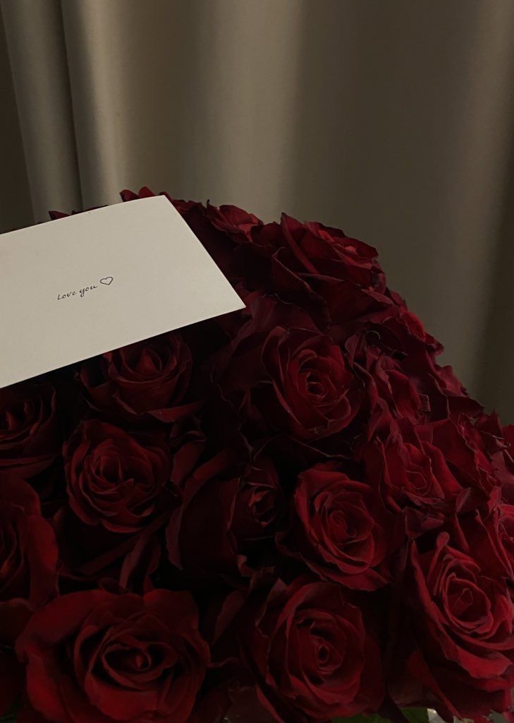 a bouquet of red roses with a note attached to the top that says i love you