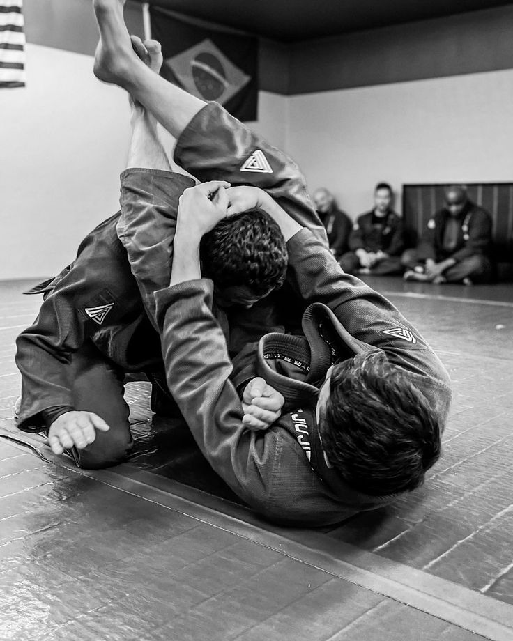 two people are wrestling in a gym