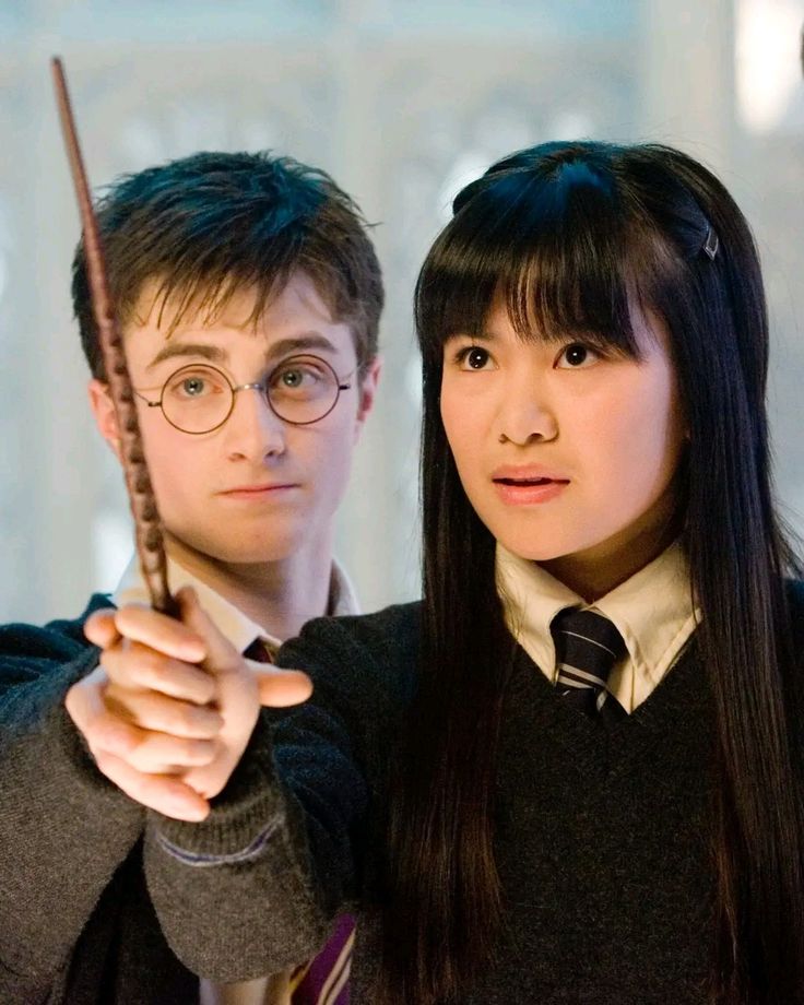 two people dressed in harry potter costumes holding wands