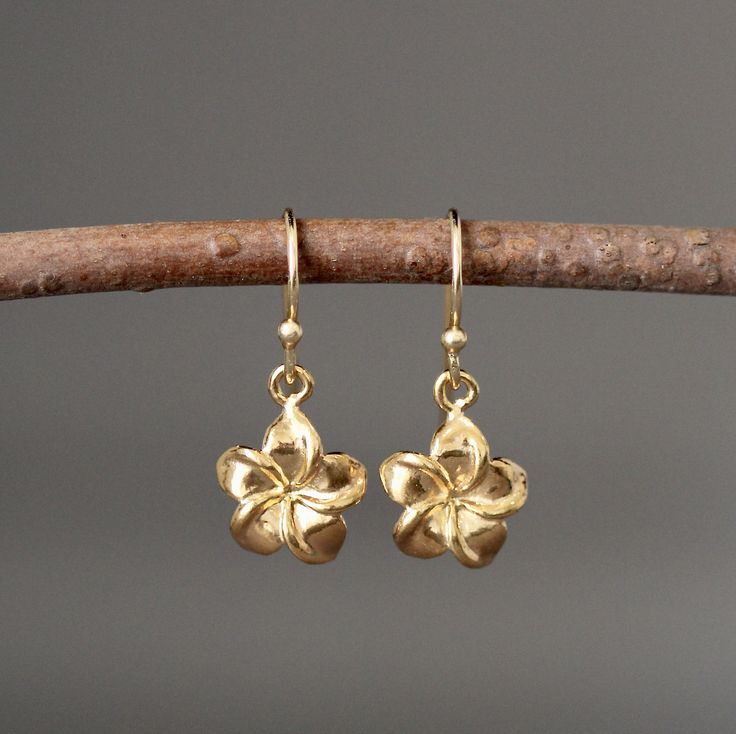 "Sweet and delicate 24k gold vermeil Plumeria flower charms dangle from 18k gold vermeil earwires. The perfect go-to-earrings for any occasion. Gold flower charms: 11x11mm Total length of earrings: 1\" All gold is gold vermeil. These earrings are also available in a larger size in silver... www.etsy.com/listing/693341987/silver-flower-earrings As the owner, maker, designer, and curator of this shop, I take great pride in providing you with jewelry that you will love to wear everyday, for special Cute Earrings Aesthetic Gold, Single Yellow Gold Flower Earring As Gift, Gold Dangle Flower Earrings In Sterling Silver, Gold Sterling Silver Dangle Flower Earrings, Yellow Gold Flower Earrings With Charm, Gold Flower-shaped Earrings With Flower Charm, Gold Flower Earrings With Charm, Gold Flower Single Earring Jewelry, Gold Flower-shaped Single Earring