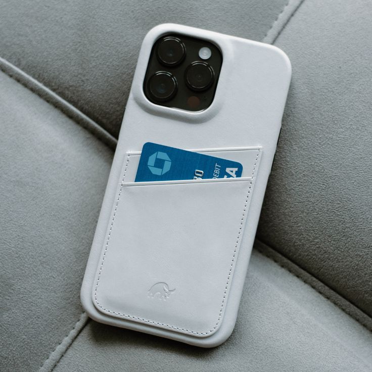 an iphone case with a credit card slot in it sitting on a seat cushion,