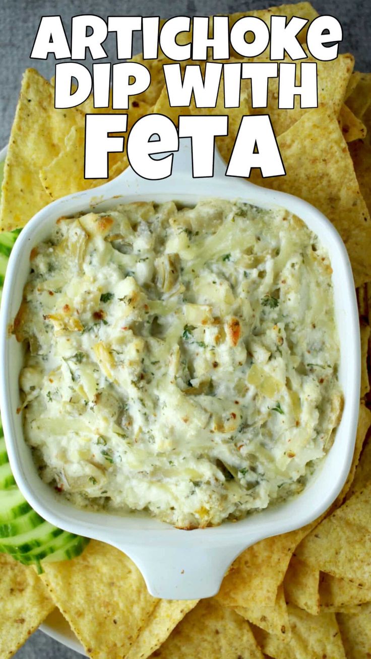 artichoke dip with feta in a bowl surrounded by tortilla chips