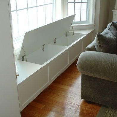 a living room filled with furniture next to a white window sill and wooden flooring