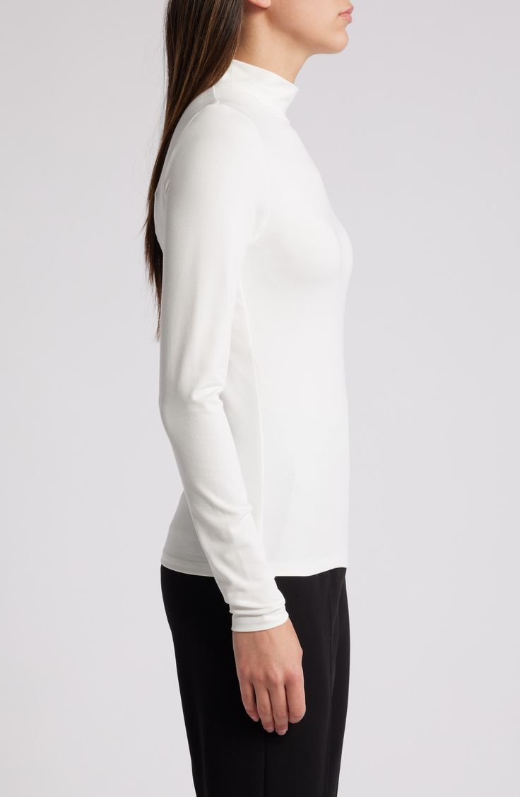 Sleek and streamlined, this long-sleeve mock-neck top is a wardrobe staple that you can wear absolutely anywhere. 23 1/2" length Mock neck Long sleeves 100% viscose Machine wash, line dry Made in Portugal Long Sleeve Turtleneck For Spring Workwear, Long Sleeve Turtleneck For Work In Spring, Solid Color Long Sleeve Mock Neck Top For Work, High Stretch Long Sleeve Tops For Workwear, Spring Long Sleeve Turtleneck For Work, Sleek Long Sleeve Turtleneck For Fall, Spring Workwear Long Sleeve Turtleneck, Long Sleeve Turtleneck With Minimal Stretch For Layering, Versatile Long Sleeve Mock Neck Top For Work