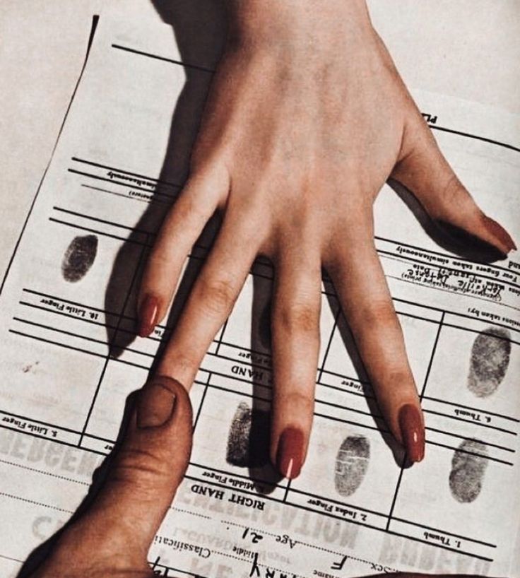 two hands are touching each other over a fake fingerprint on a sheet of paper