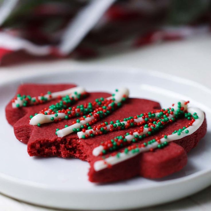 red velvet cookies decorated with green and white sprinkles on a white plate