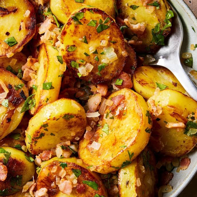 cooked potatoes with bacon and parsley in a bowl