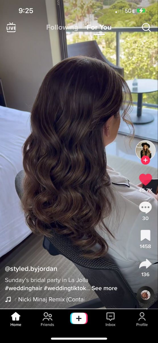 the back of a woman's head with long dark hair and wavy brown hair