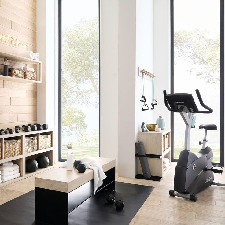 there is a gym with exercise equipment in the room and towels on the rack next to it