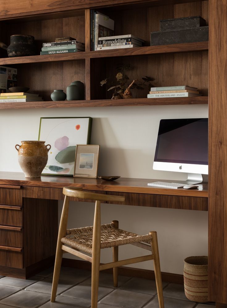 a wooden desk with a computer monitor and keyboard sitting on it's top shelf