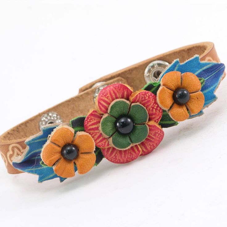 This cute flower bracelet is a great gift for all girls and women during the holidays, and it fits nicely around your wrist, adjustable by the two snaps on it. dimensions: 8.5 inches by 0.5 inches Adjustable Flower Decorated Jewelry For Spring, Spring Adjustable Bohemian Cuff Bracelet, Spring Gift Cuff Bracelet, Spring Gift Adjustable Cuff Bracelet, Adjustable Flower Cuff Bracelet For Spring, Adjustable Spring Cuff Bracelet As Gift, Adjustable Spring Cuff Bracelet Gift, Unique Adjustable Flower-shaped Jewelry, Adjustable Multicolor Leather Bracelet Gift