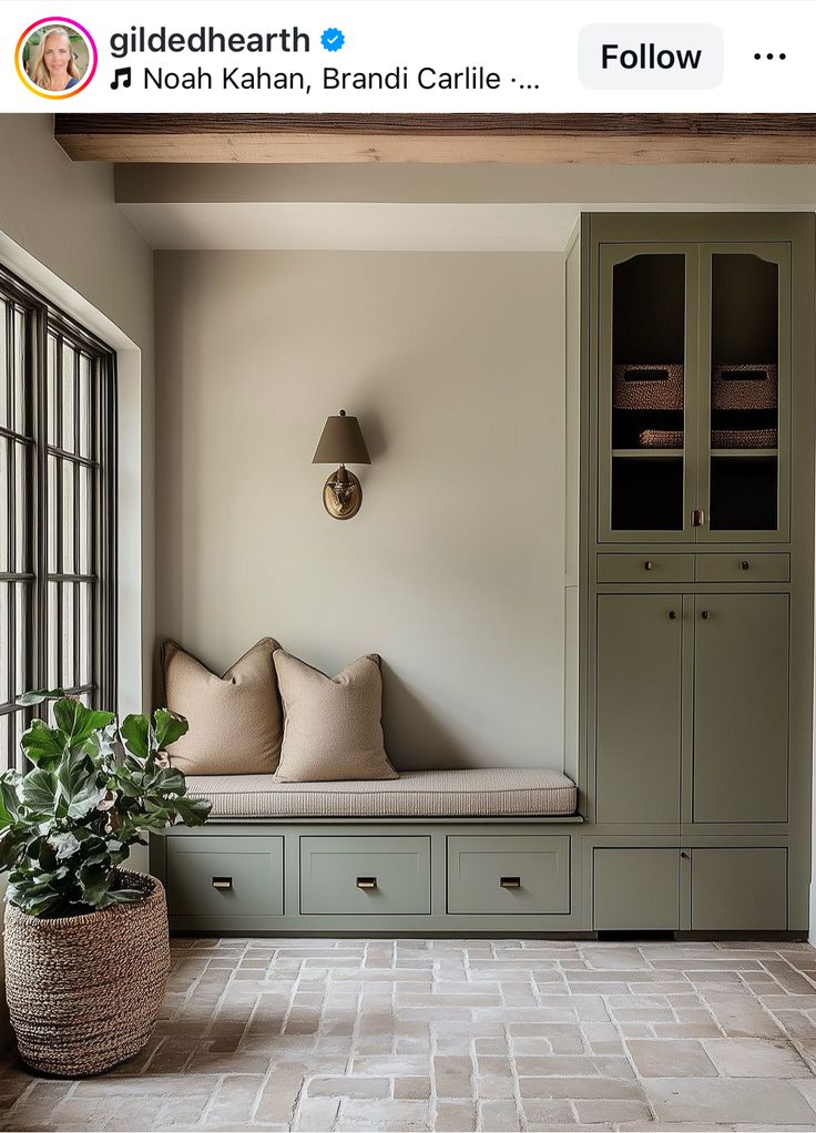 a window seat in the corner of a room next to a bookcase and potted plant