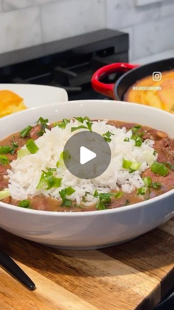 a bowl filled with rice and meat on top of a wooden table