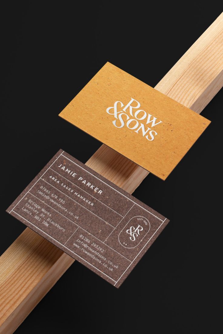 a business card sitting on top of a wooden stick with the word grow sons printed on it