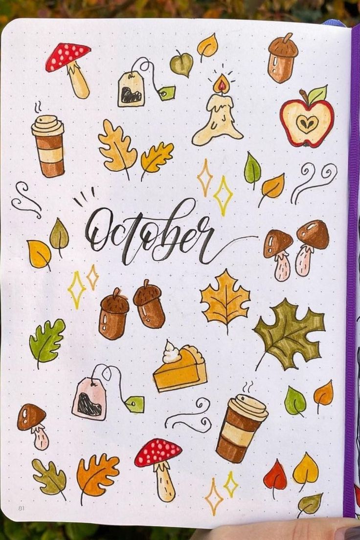 someone holding up a notebook with autumn doodles on it