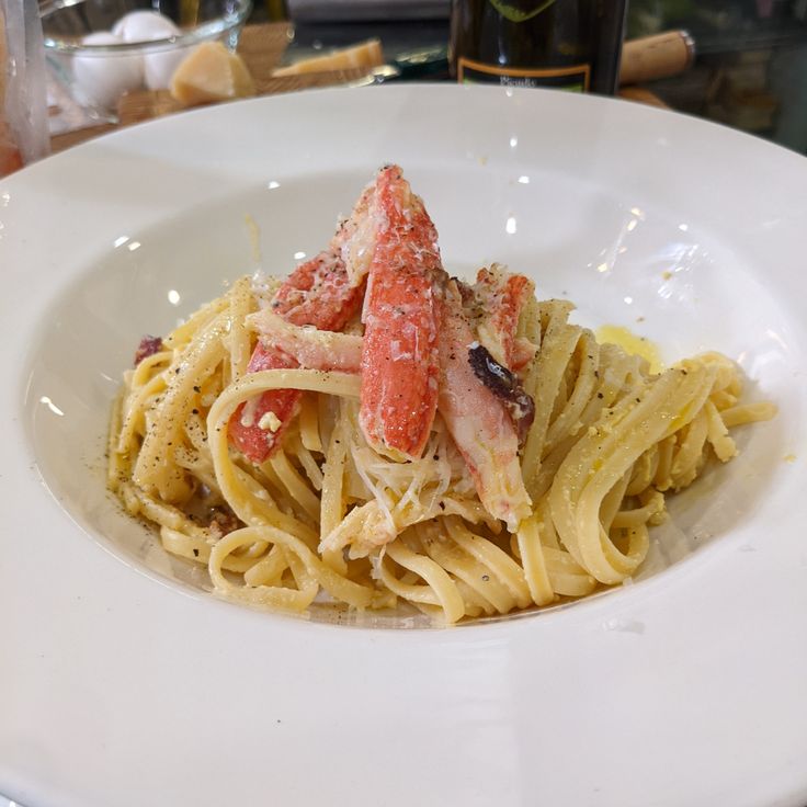 a white plate topped with pasta and lobster