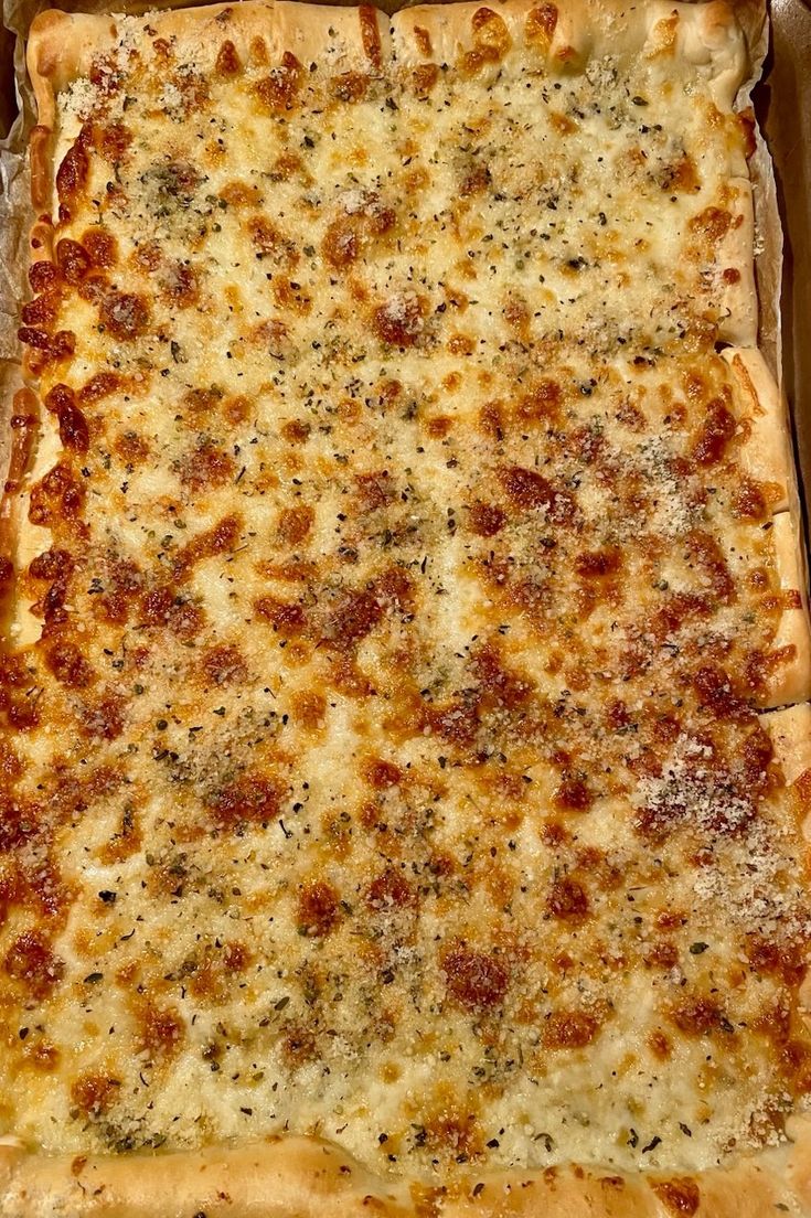 a square pizza in a box with cheese and sauce on it's crusts