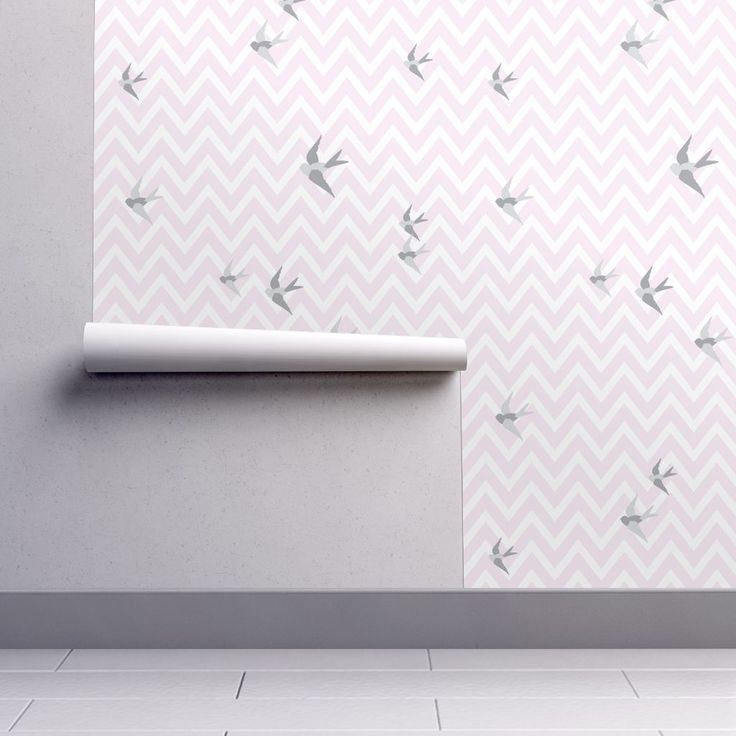 a white wall with birds on it next to a roll of toilet paper