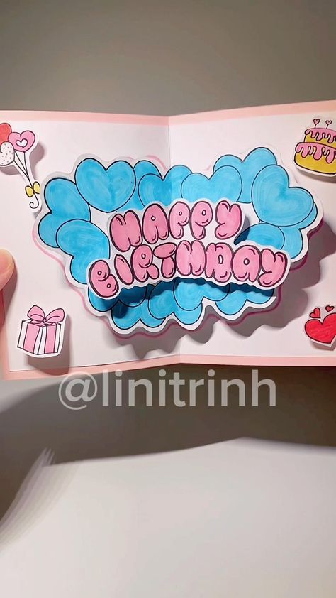 someone is holding up a pink and blue birthday card