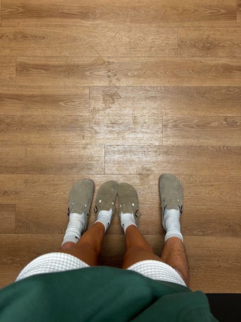 a person standing on top of a wooden floor with their feet up in the air