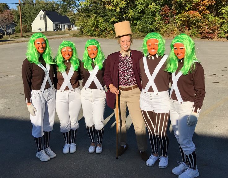 a group of people with green wigs and suspenders are standing in the street