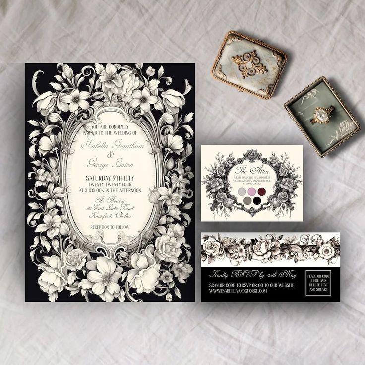 the wedding stationery is laid out on top of a white sheet with black and white flowers