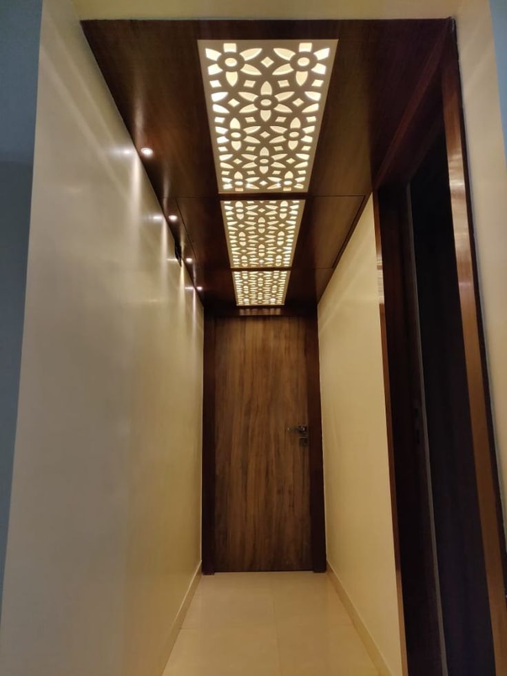 an empty hallway with lights on the ceiling