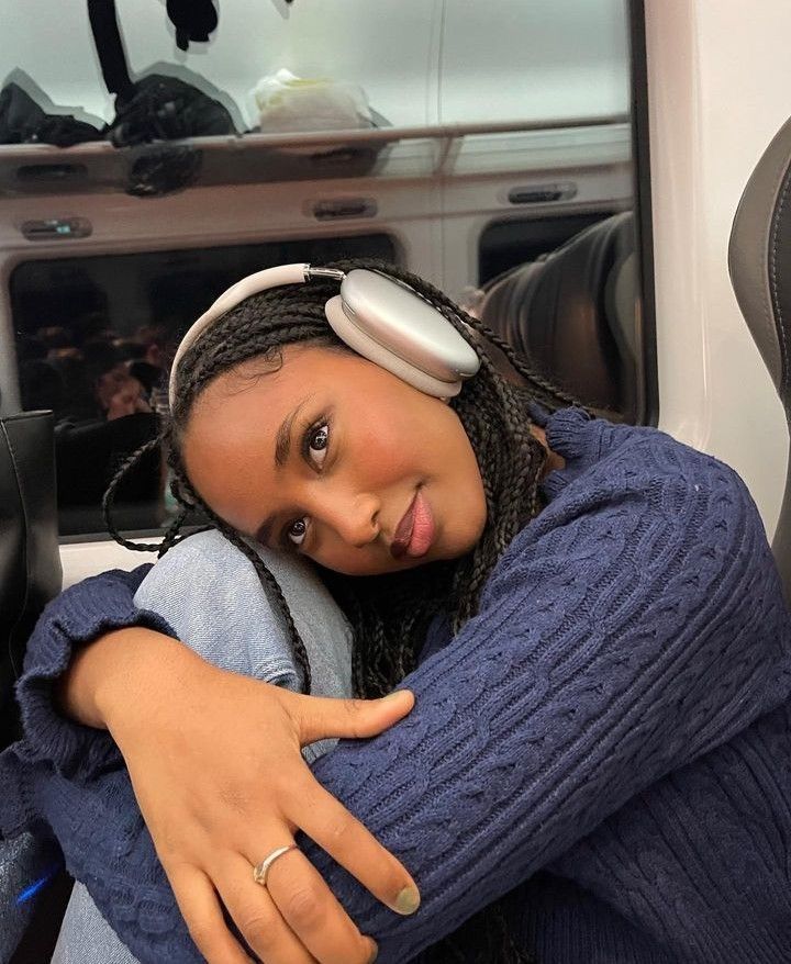 a woman with headphones sitting on a bus