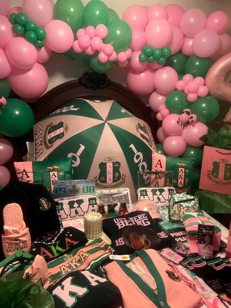 a sports themed birthday party with balloons and t - shirts on the bed in front of it