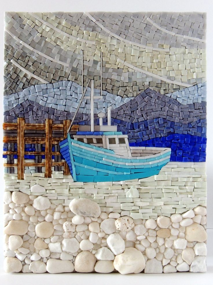 a blue and white boat sitting on top of a rock covered beach next to the ocean