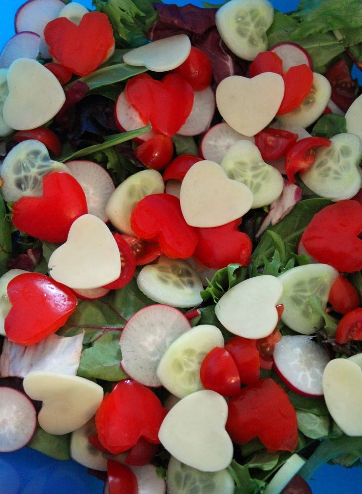 heart shaped veggies are mixed together in a blue bowl