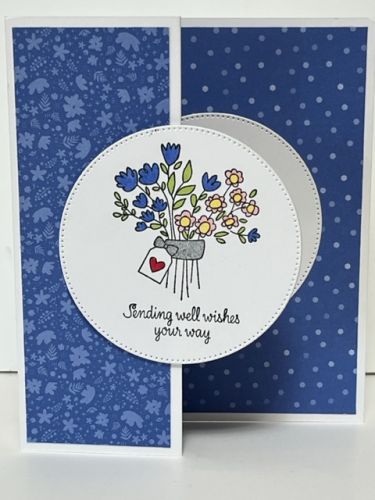 a handmade card with blue and white flowers in a vase on the inside of it