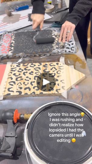 a person using a power drill to cut out decorative tiles on a table with other items