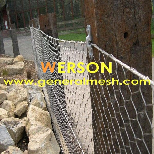 a chain link fence is next to some rocks