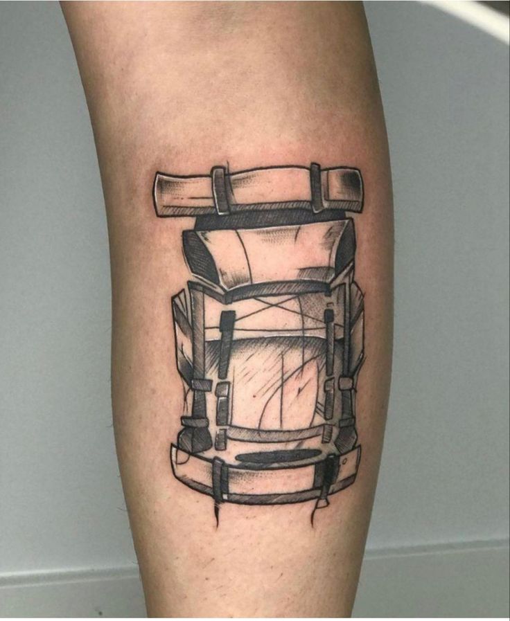 a tattoo on the leg of a person with a pencil and ink drawing of a suitcase