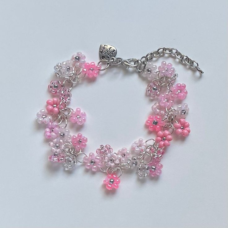 "A sweet handmade bracelet ✿ Made with glass seed beads and silver accents ✿ An assortment of pinks, bubblegum, blush, rose, milky white, and silver ✿ The bracelet has an additional 1-1.5\" of extension chain" Silver Beaded Bracelets With Flower Charm, Pink Hypoallergenic Beaded Bracelets, Pink Flower Charm Bracelet For Jewelry Making, Pink Charm Bracelet With Silver Beads, Ideal For Gifting, Pink Charm Bracelet With Silver Beads For Gift, Pink Charm Bracelet With Silver Beads As A Gift, Pink Bracelets With Flower Charm And Round Beads, Adjustable Pink Beaded Bracelet With Silver Beads, Pink Adjustable Chain Bracelet Gift