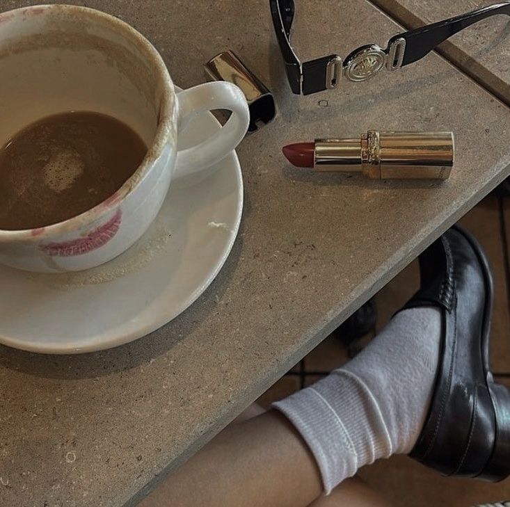 a cup of coffee on a saucer next to a pair of scissors