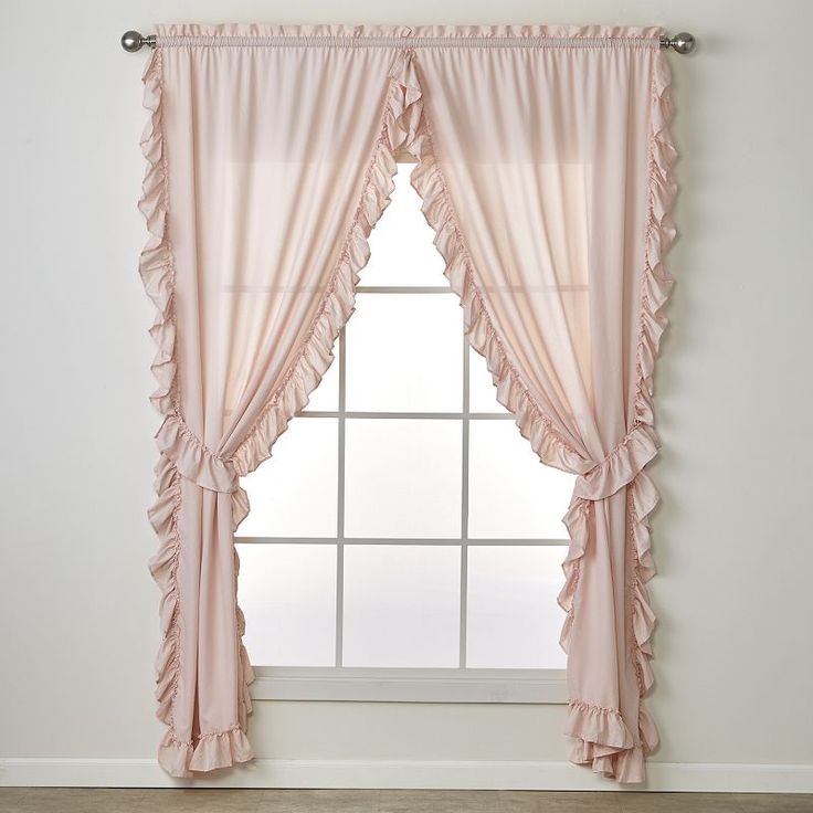 a pink curtain with ruffled edges hangs in front of a white wall and window