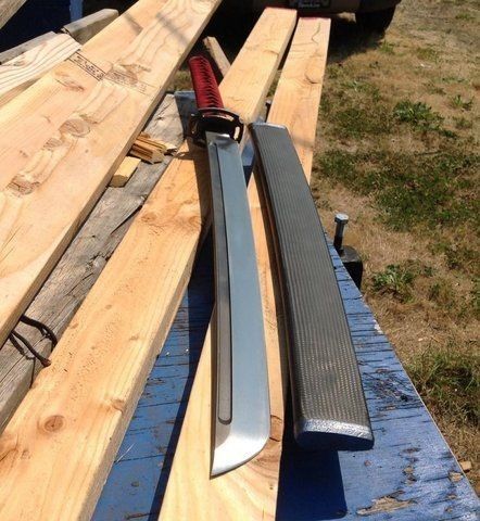 a knife is laying on top of some wood planks next to a pick - up truck