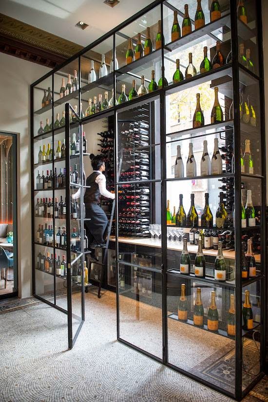 a man standing in front of a display case filled with bottles