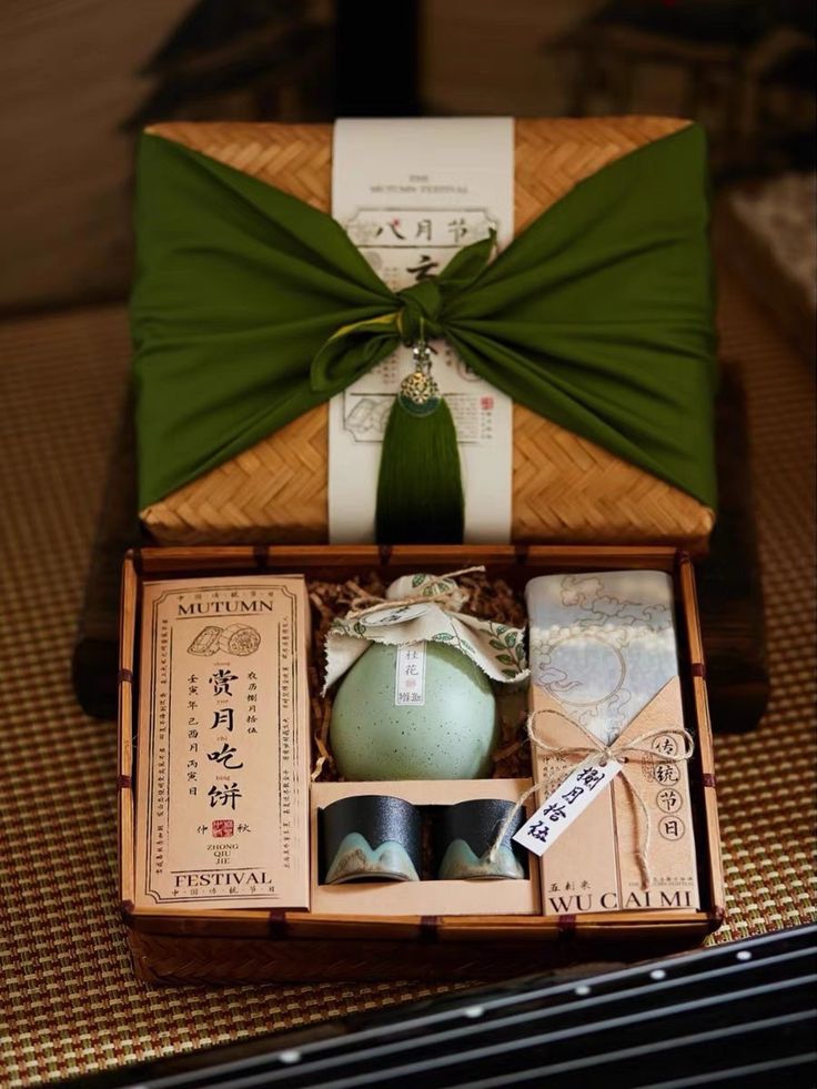 an open box with some items in it and a green bow on the top one